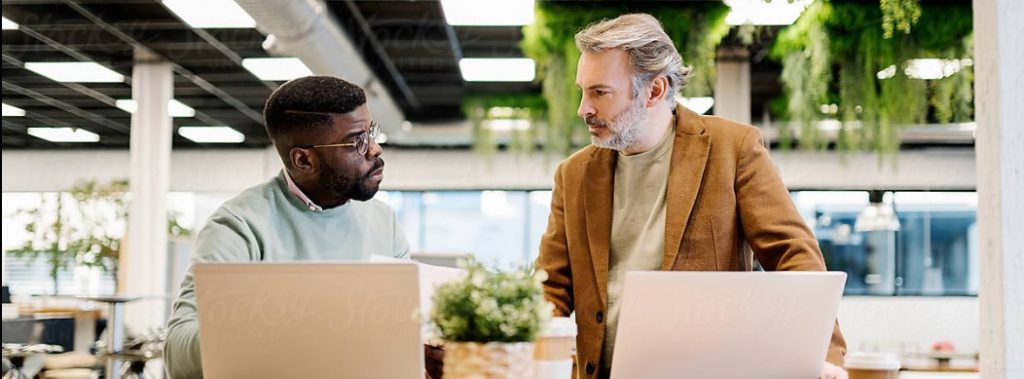 Professionals collaborating with laptops